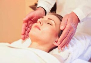 Massagem facial aplicada em uma hóspede deitada